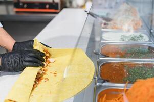 Chef preparing shawarma or kebab using fresh ingredients photo