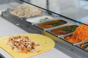 Chef preparing delicious shawarma with chicken and various ingredients photo