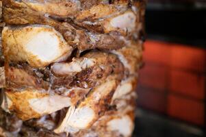 Juicy chicken shawarma rotating on a spit photo