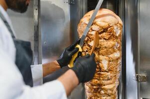 Chef preparing shawarma or kebab with large knife and spatula photo