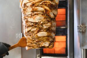 Chef preparing shawarma or doner kebab with chicken meat in a restaurant photo