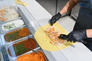 Chef preparing delicious shawarma or kebab with fresh ingredients photo