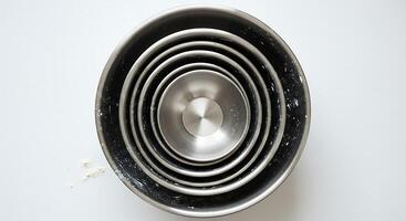 Nesting Stainless Steel Bowls Arranged on White Surface, Overhead View photo