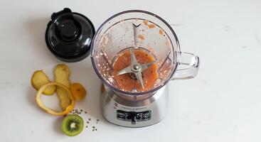 Making Smoothie with Blender and Fresh Fruit on White Countertop photo