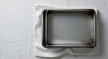 Empty Baking Pans Resting on White Cloth with Leftover Food photo