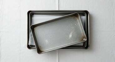Overhead View of Baking Sheets and Parchment Paper on a White Surface photo