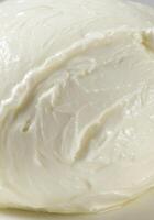 A close up view of a fresh ball of creamy white mozzarella cheese. photo