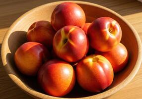 Close up shot of ripe nectarines in a wooden bowl, ready to be enjoyed. photo