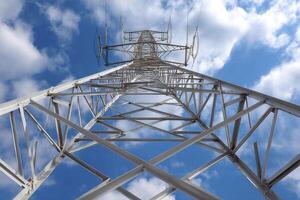 A high voltage tower with clouds in the background photo