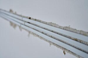Close-up of white electrical cables embedded in wall groove during wiring installation. Concept of electrical work, construction or renovations photo