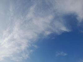 Clear blue sky with soft, wispy white clouds creating a calm and peaceful atmosphere, ideal for nature and outdoor themed designs photo