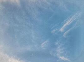 Clear blue sky with soft, wispy clouds creating a calm and peaceful atmosphere, ideal for nature, weather, or relaxation-themed visuals. photo