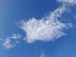 Clear blue sky with soft, wispy clouds creating a calm and peaceful atmosphere, perfect for nature and outdoor-themed visuals photo