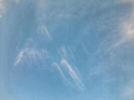 Clear blue sky with soft, scattered white clouds creating a calm and peaceful atmosphere, perfect for nature or weather-themed visuals. photo
