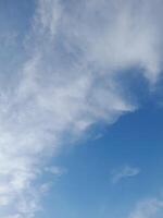 Clear blue sky with soft, wispy clouds creating a calm and peaceful atmosphere, perfect for nature and outdoor-themed visuals. photo