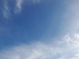 Clear blue sky with soft, wispy white clouds creating a calm and peaceful atmosphere, ideal for nature and outdoor-themed designs photo