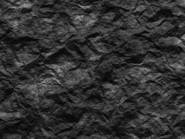 Dark rocky texture with rough, sharp edges and irregular formations. photo