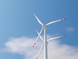 Low-angle view of a wind turbine with red-tipped blades in the sky. photo