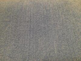 Close-up of a gray twill fabric with diagonal weave patterns, giving a textured yet smooth and durable appearance. photo