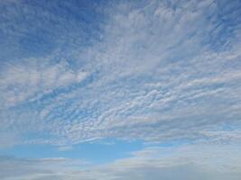 A beautiful sky filled with scattered, fluffy white clouds against a soft blue backdrop, creating a calm and serene atmosphere. photo