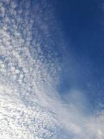 A clear blue sky with scattered white clouds, creating a calm and peaceful atmosphere above photo