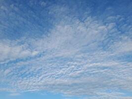 A calm blue sky filled with soft, scattered clouds, creating a peaceful and serene atmosphere. photo