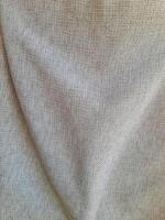 A close-up of beige woven fabric with visible folds and texture, offering a natural, rustic, and organic appearance for decor, crafts, or eco-friendly projects. photo