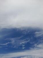 A bright blue sky with soft, scattered white clouds drifting peacefully, creating a calm and serene atmosphere. photo