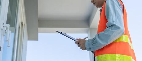 inspector or engineer is inspecting construction and quality assurance new house using a checklist. Engineers or architects or contactor work to build the house to the homeowner photo