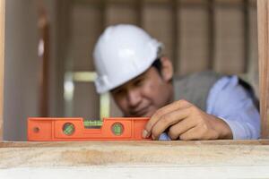Contactor or engineer is inspect construction and quality assurance new house using a level. Engineers or architects or contactor work to build the house before handing it over to the homeowner photo