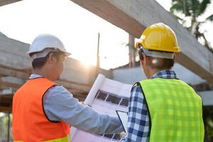 engineer is inspecting construction and quality assurance new house using a blue print. Engineer or architects or contactor work to build the house before handing it over to the homeowner photo