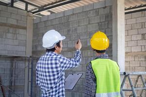 inspector engineer and owner project is inspecting construction and quality assurance new house. Engineers or architects or contactor work to build the house. photo
