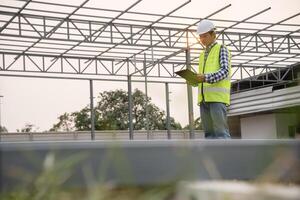 inspector is inspecting construction house using a checklist. Engineers and architects or contactor count materials for construction. Building, check, insurance house, quality, foreman. photo