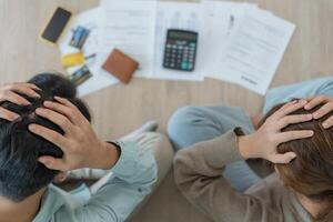 Stressed and headache couple with large bills or invoices no money to pay to expenses and credit card debt. shortage, Financial problems, mortgage, loan, bankruptcy, bankrupt, poor, empty wallet photo