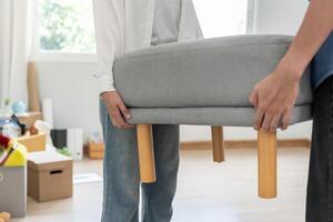 Moving house. relocation. Couple help set sofa and move furniture for new apartment, inside the room was a cardboard box contain personal belongings. move in the new apartment or condominium photo