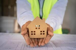 inspector, engineer, Foreman or contactor show house model make confident inspect the quality of his work. architects work to build the house before handing it over to the homeowner. photo