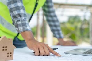 inspecting construction and quality assurance new house using a blue print. Engineer or architects or contactor work to build the house before handing it over to the homeowner photo