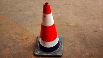 A traffic cone on a concrete surface photo