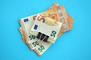 Big amount of european euro currency money notes on blue color table close up photo
