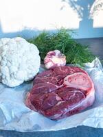 Raw Beef Shank with Bone Fresh Vegetables on Parchment Paper photo