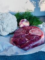 Beef Shank with Bone and Fresh Vegetables on Parchment Paper photo