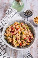 A bowl of cooked rice and vegetables for garnish on the table vertical view photo