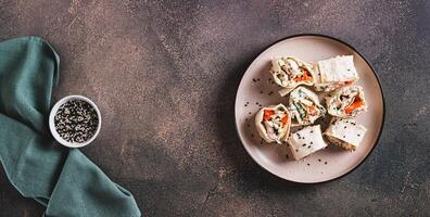 Flat bread rolls with chicken and vegetables on a plate on the table top view web banner photo