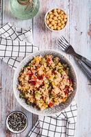 A bowl of cooked rice and vegetables for garnish on the table top and vertical view photo