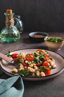 Appetizing salad of white beans, cherry tomatoes and parsley on a plate vertical view photo