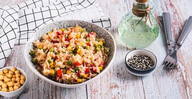Homemade fried rice with peas, corn and pepper in a bowl on the table web banner photo