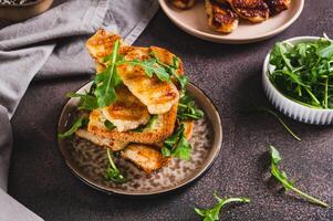 Grilled halloumi and arugula sandwich on a plate on a table photo