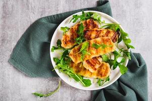 Close up of warm salad with grilled halloumi and arugula on a plate on the table top view photo