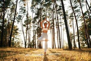 Stretching,,, up,, warm up exercises. Woman is doing yoga fitness exercises in the forest photo