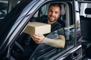 The delivery man or a loader, is, in, the car with box photo